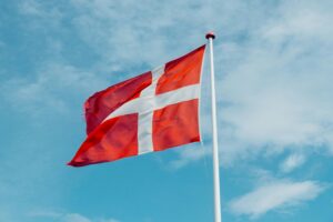 Red and white Danish flag fluttering in the wind, symbolizing national pride on a clear day.