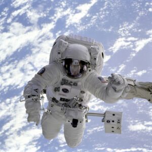 Astronaut conducting a spacewalk with Earth in the background, showcasing outer space exploration.